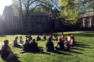 Group of YogaWell students meditating on grass